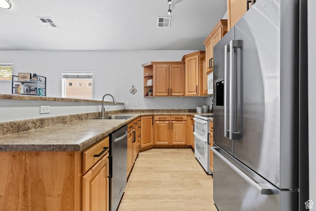kitchen with appliances with stainless steel finishes, a sink, light wood-style flooring, a peninsula, and open shelves