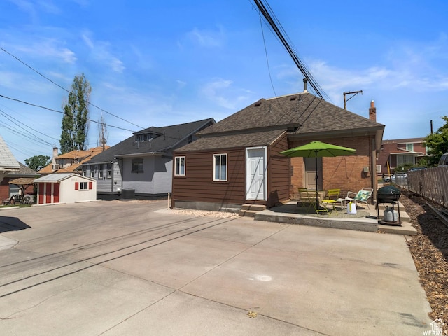 1318 E 300 S, Salt Lake City, UT 84102 - back of property featuring entry steps, fence, a shingled roof, a patio, and an outbuilding
