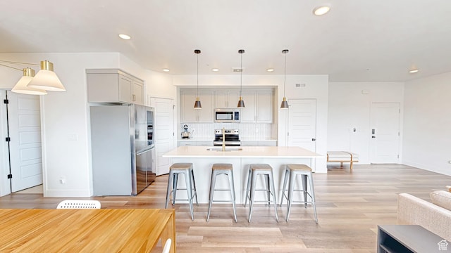 376 S 1080 W Unit 301, American Fork, UT 84003 - kitchen with stainless steel appliances, light countertops, decorative backsplash, a center island with sink, and recessed lighting