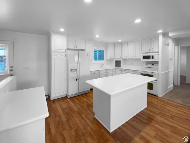 2987 S Eucalyptus Way, West Valley City, UT 84119 - kitchen with white appliances, a sink, white cabinets, a kitchen island, and plenty of natural light
