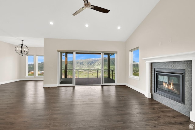 4491 N Seven Bridges Rd, Eden, UT 84310 - unfurnished living room with a tile fireplace, ceiling fan, dark wood-style floors, a chandelier, and baseboards
