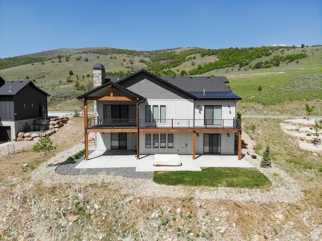 4491 N Seven Bridges Rd, Eden, UT 84310 - rear view of house with a patio area, a chimney, and a mountain view