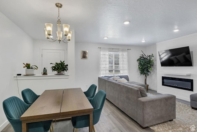 4013 W Cool Ave, Lehi, UT 84043 - dining area with a chandelier, wood finished floors, a glass covered fireplace, recessed lighting, and baseboards