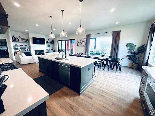 39 W Tamarind Way, Garden City, UT 84028 - kitchen with a fireplace, dishwasher, a sink, light countertops, and light wood-style floors