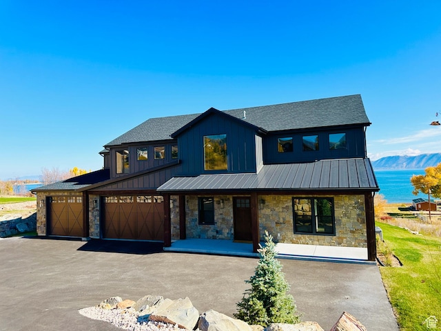 39 W Tamarind Way, Garden City, UT 84028 - view of front of property with stone siding, covered porch, a standing seam roof, roof with shingles, and driveway