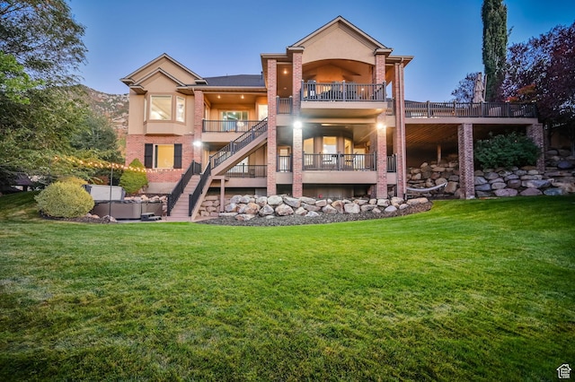 8 Snow Forest Cv, Sandy, UT 84092 - rear view of house featuring stairway, brick siding, stucco siding, a balcony, and a lawn
