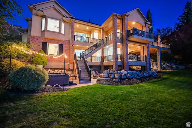 8 Snow Forest Cv, Sandy, UT 84092 - back of house at night featuring stucco siding, stairway, brick siding, and a yard