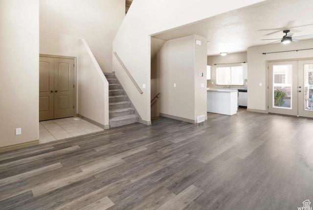 5117 W Fortrose Dr, Herriman, UT 84096 - unfurnished living room with french doors, a ceiling fan, wood finished floors, and stairway