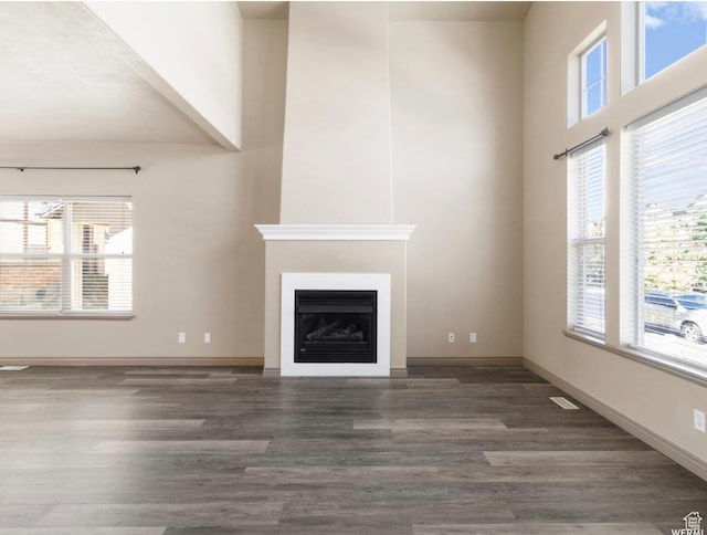 5117 W Fortrose Dr, Herriman, UT 84096 - unfurnished living room featuring wood finished floors, a fireplace, healthy amount of natural light, and a high ceiling