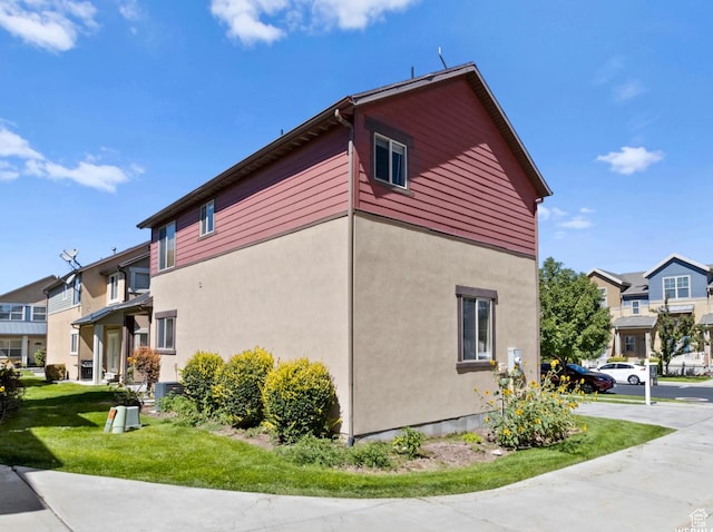 5117 W Fortrose Dr, Herriman, UT 84096 - view of side of property featuring a residential view, a lawn, and stucco siding