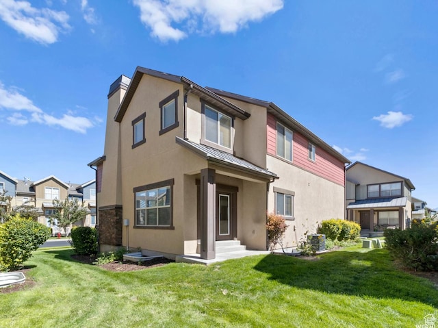 5117 W Fortrose Dr, Herriman, UT 84096 - rear view of house featuring a standing seam roof, stucco siding, metal roof, and a lawn