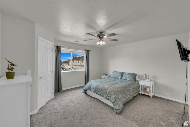 carpeted bedroom with baseboards, ceiling fan, and a textured ceiling