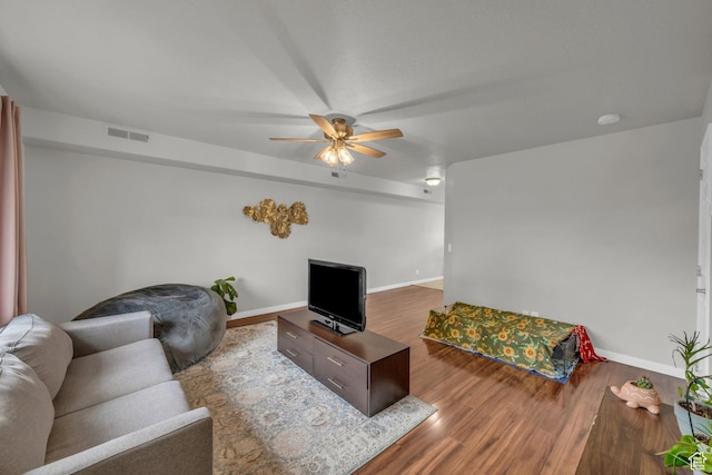 living room with a ceiling fan, wood finished floors, and baseboards