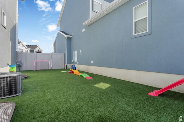 view of yard with central AC unit and a gate