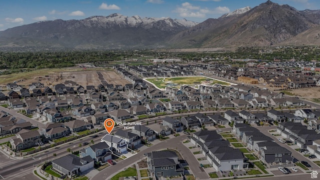 aerial view of property and surrounding area featuring a mountain backdrop and nearby suburban area