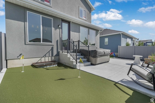 view of patio / terrace with an area to practice putting and fence