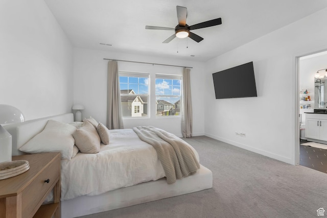 carpeted bedroom with baseboards, ensuite bathroom, and ceiling fan