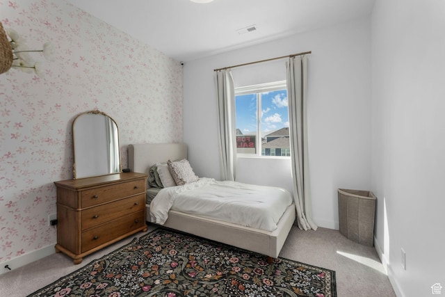 bedroom featuring light colored carpet, wallpapered walls, and baseboards