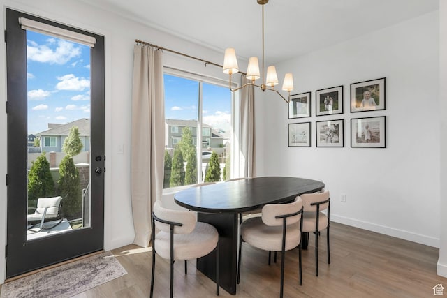 dining room with a chandelier, wood finished floors, and baseboards