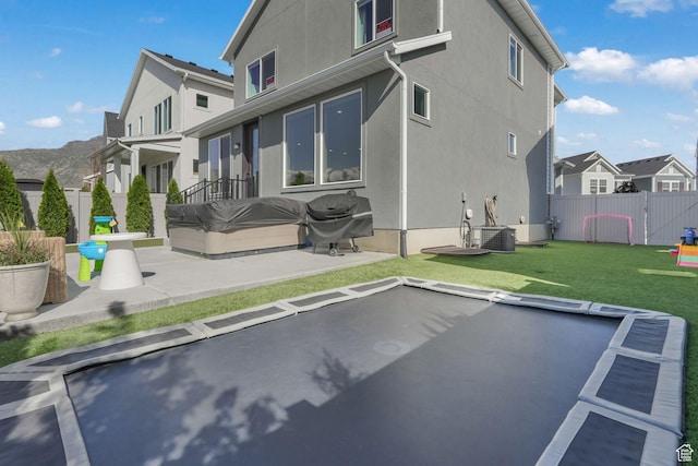 rear view of house featuring a residential view, stucco siding, a patio area, central AC, and a gate
