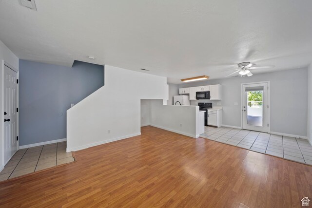 1957 N 2225 W, Clinton, UT 84015 - unfurnished living room with light wood-type flooring, ceiling fan, and baseboards