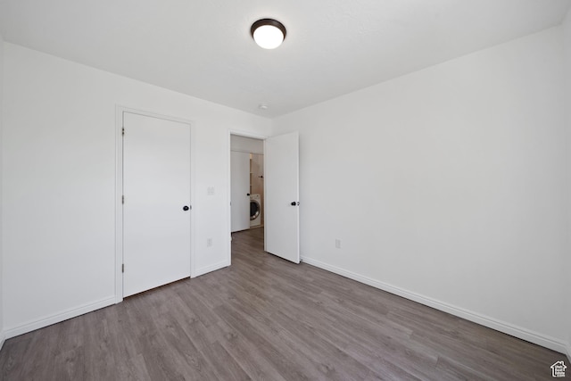 1957 N 2225 W, Clinton, UT 84015 - unfurnished bedroom featuring wood finished floors, baseboards, and washer / clothes dryer