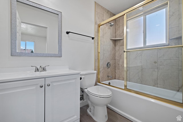 bathroom featuring healthy amount of natural light, wood finished floors, enclosed tub / shower combo, and toilet