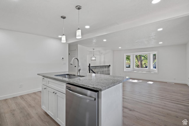 kitchen featuring dishwasher, a sink, open floor plan, light wood-type flooring, and recessed lighting