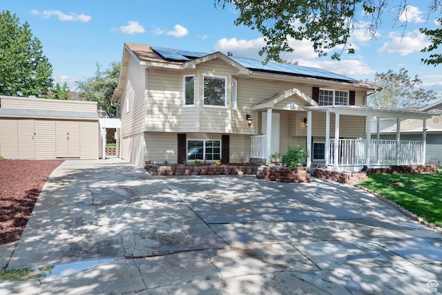 view of front of house featuring covered porch, solar panels, and an outbuilding