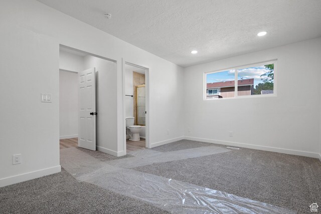 unfurnished bedroom featuring carpet, baseboards, recessed lighting, a textured ceiling, and connected bathroom