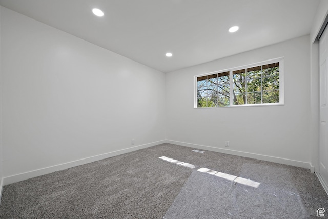 carpeted empty room featuring baseboards and recessed lighting