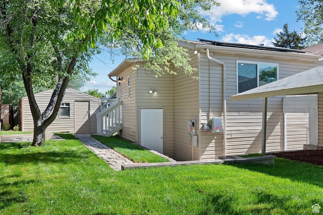 back of property with a yard and an outdoor structure