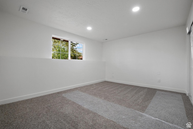 empty room featuring carpet, recessed lighting, and baseboards