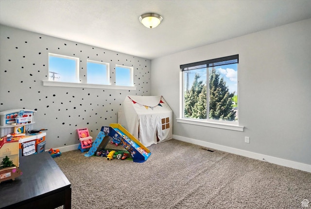 recreation room with carpet and baseboards