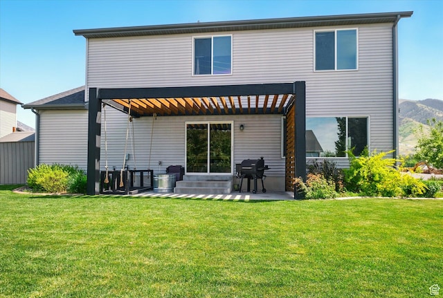 rear view of house featuring a patio, a lawn, and a mountain view