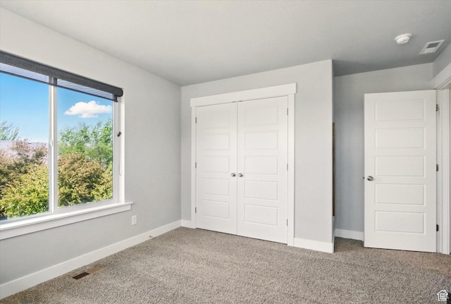 unfurnished bedroom featuring carpet floors, baseboards, and a closet