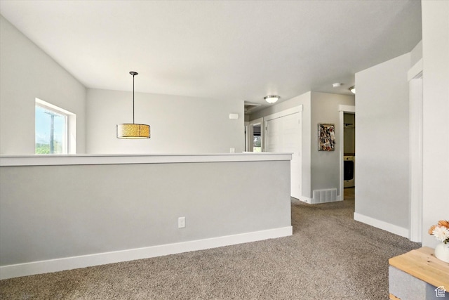 carpeted spare room with baseboards and washer / clothes dryer