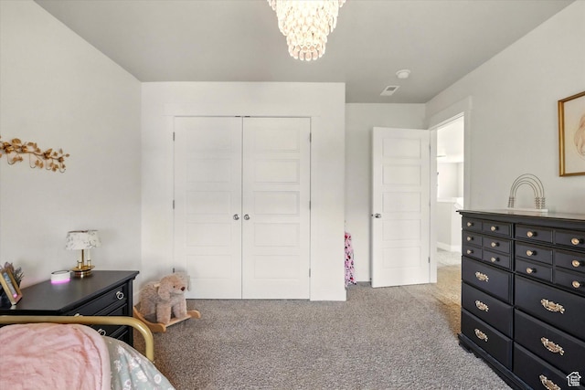 carpeted bedroom with a closet and a chandelier