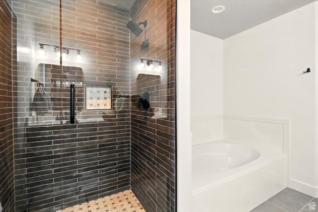 bathroom with a bath, a tile shower, and tile patterned floors