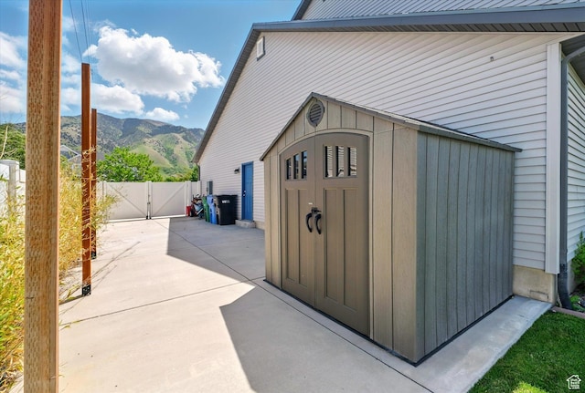 view of shed with a gate, a mountain view, and fence