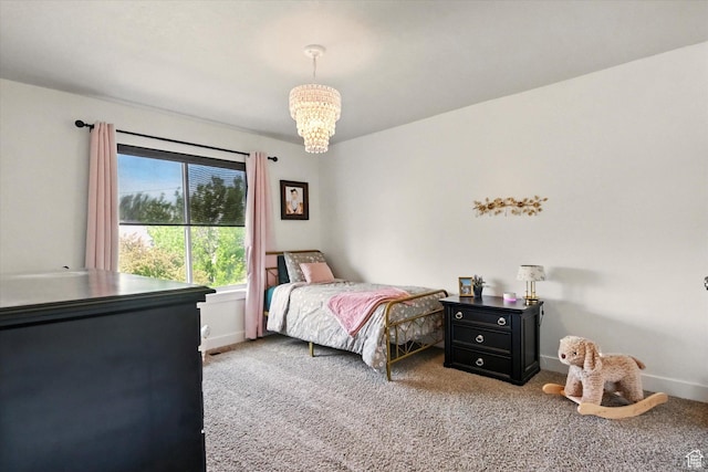 carpeted bedroom with a chandelier and baseboards