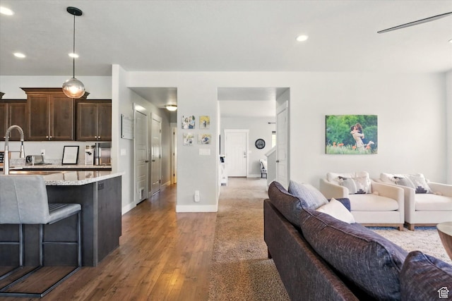 living area with wood finished floors, recessed lighting, and baseboards