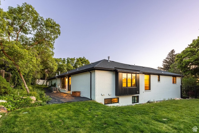 4279 S Lares Cir, Salt Lake City, UT 84124 - back of property featuring brick siding, a yard, a patio area, and central AC unit