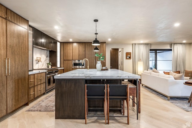4279 S Lares Cir, Salt Lake City, UT 84124 - kitchen featuring stainless steel appliances, modern cabinets, a kitchen bar, a large island, and light wood-type flooring