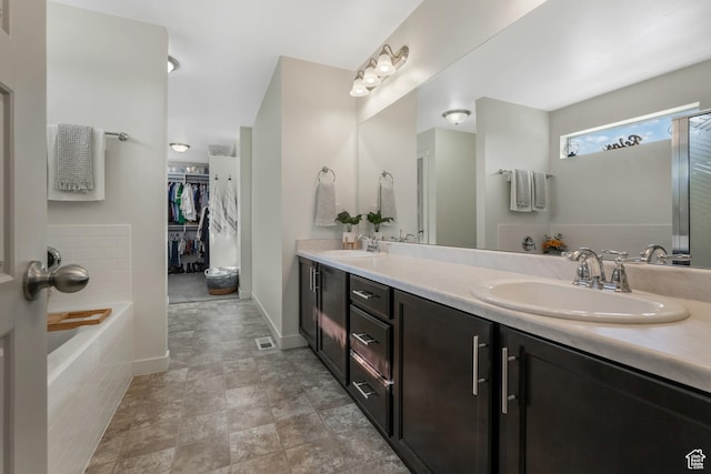 9559 S Lea Heather Way, West Jordan, UT 84081 - full bathroom with double vanity, a walk in closet, and a relaxing tiled tub