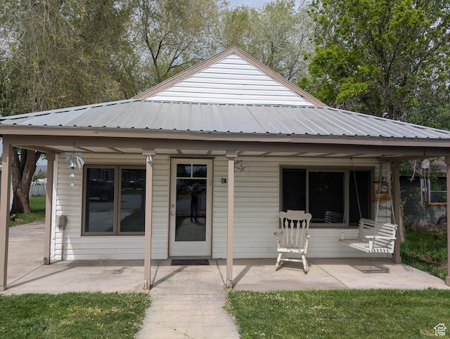 back of property with a patio and metal roof