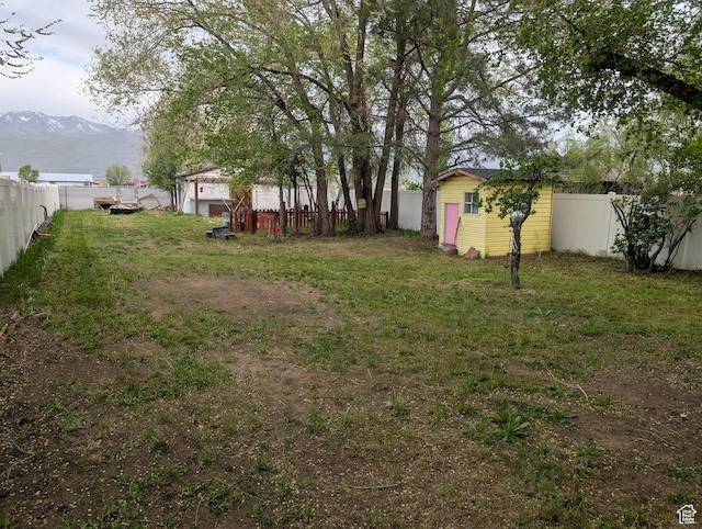 fenced backyard featuring a mountain view and an outdoor structure