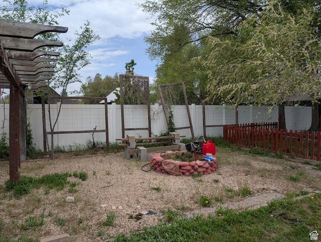 fenced backyard featuring a fire pit