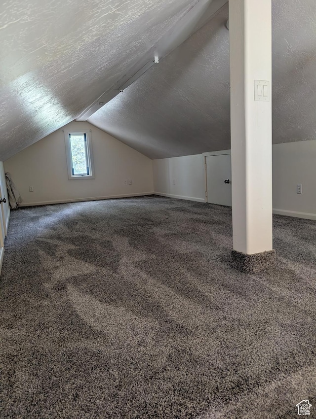 bonus room featuring a textured ceiling, vaulted ceiling, baseboards, and carpet floors