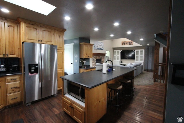 463 E 200 N, Mapleton, UT 84664 - kitchen with stainless steel appliances, open floor plan, dark countertops, a stone fireplace, and dark wood-type flooring
